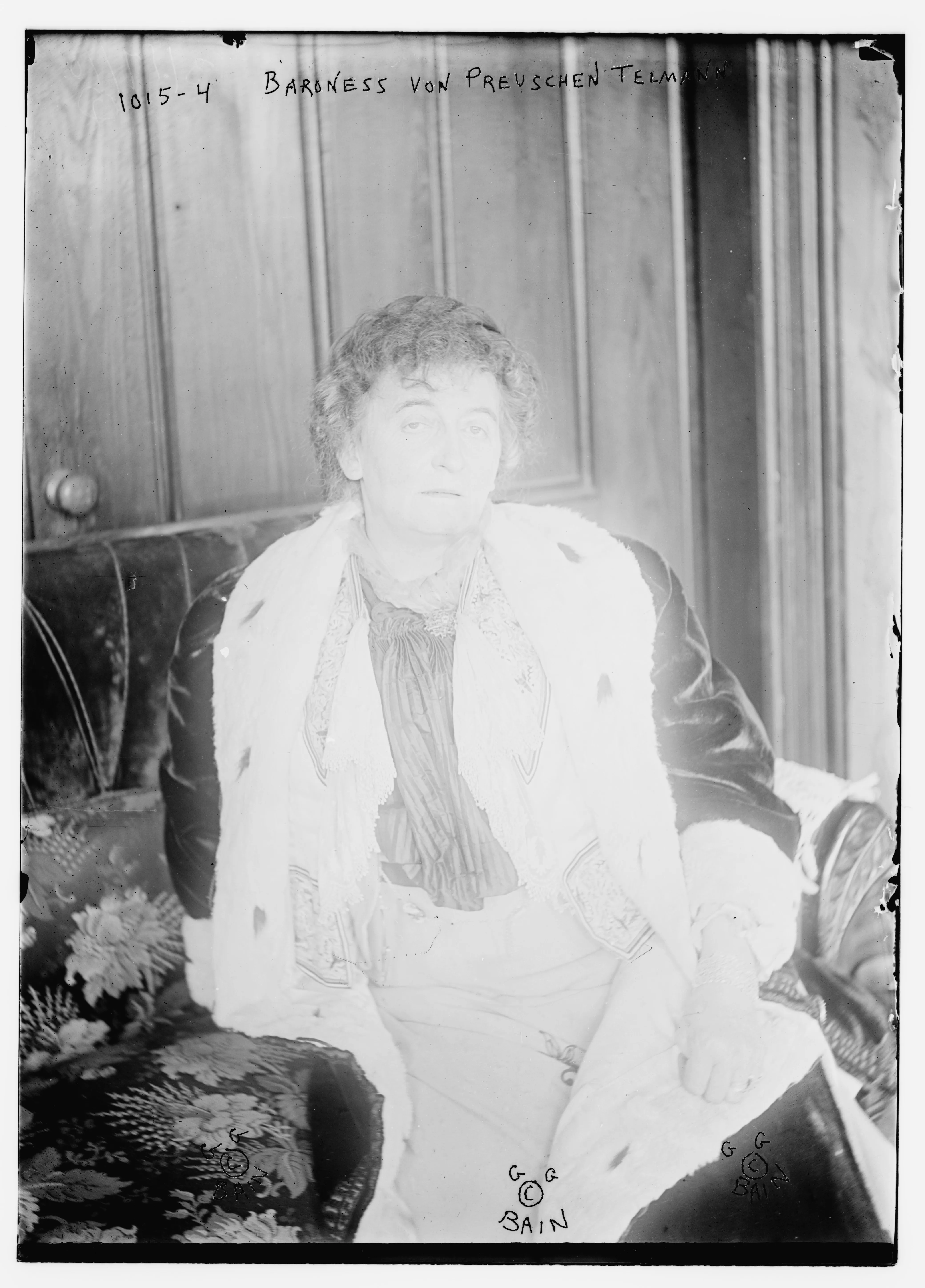 Studio photograph of Hermione von Preuschen-Telmann, seated on a sofa in an ornate interior.