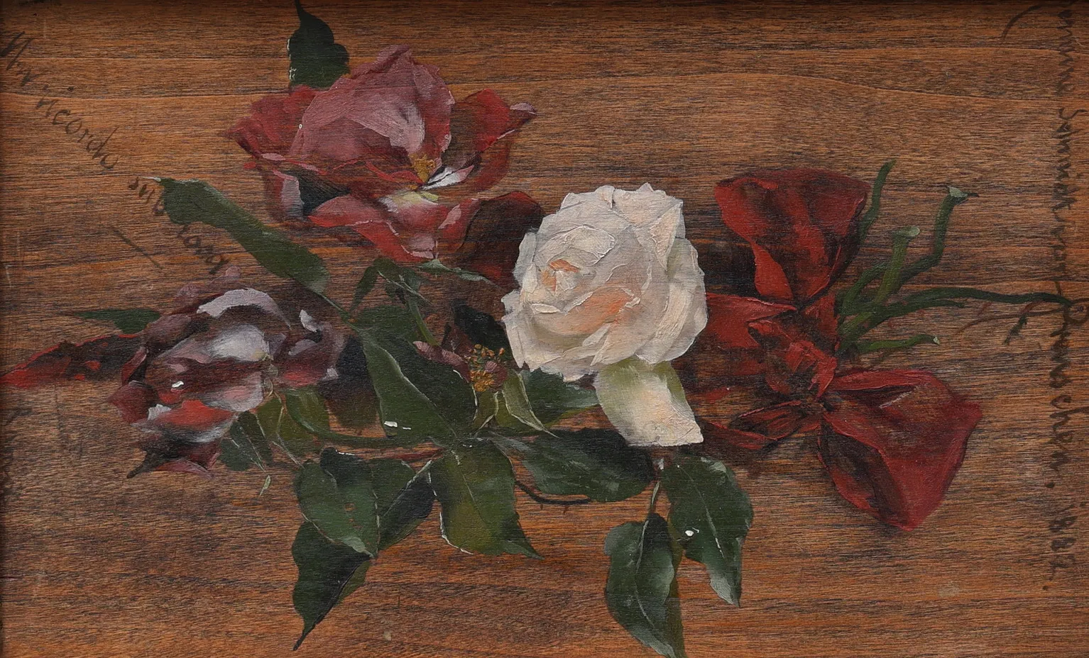 Red and white roses with dark glossy foliage laid on a bare wooden panel, with a faint handwritten inscription.